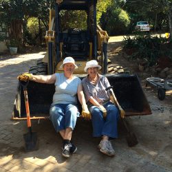 Two ladies sitting on frontend loader